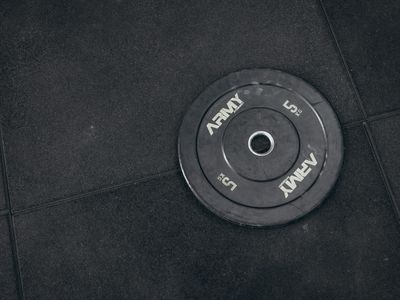 Detail of a kettlebell sitting on a dark rubber floor